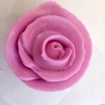 Photo of a rosette made out of pink cake frosting.