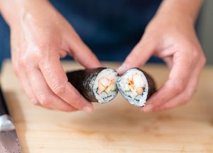 Close up of a sushi roll with nori seaweed on the outside