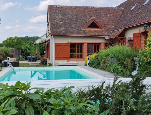 French country retreat with a pool and lush greens